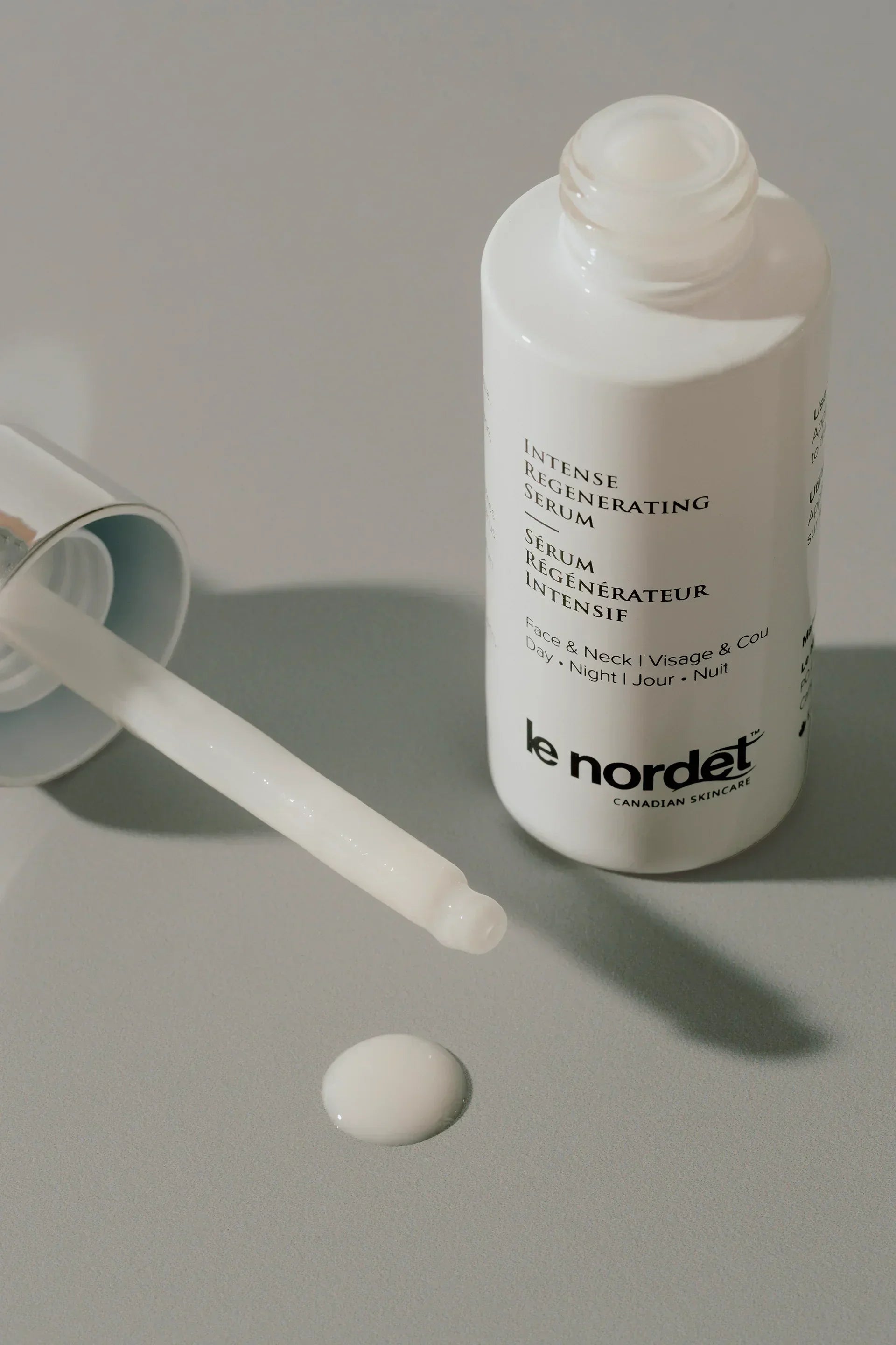 Intense Regenerating Serum for face and neck, with dropper and drop on surface